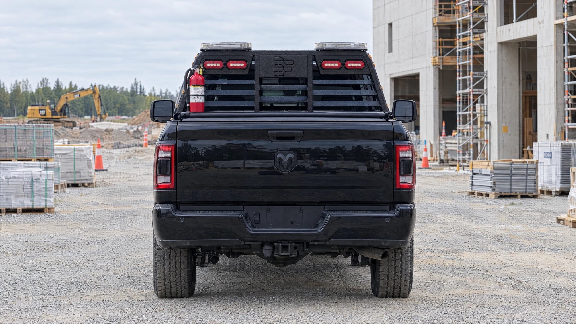 Visuel de présentation du Ram 2500 2025 avec son rack HDR, vu de l’arrière dans un décor de chantier.